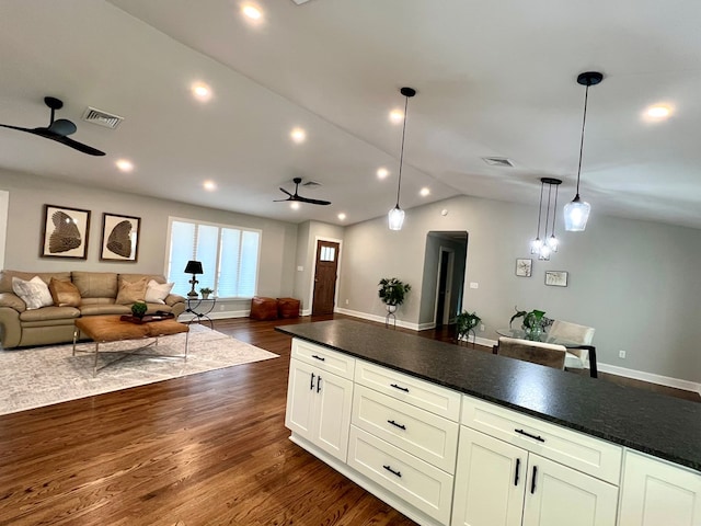 kitchen featuring ceiling fan, dark hardwood / wood-style floors, vaulted ceiling, and hanging light fixtures