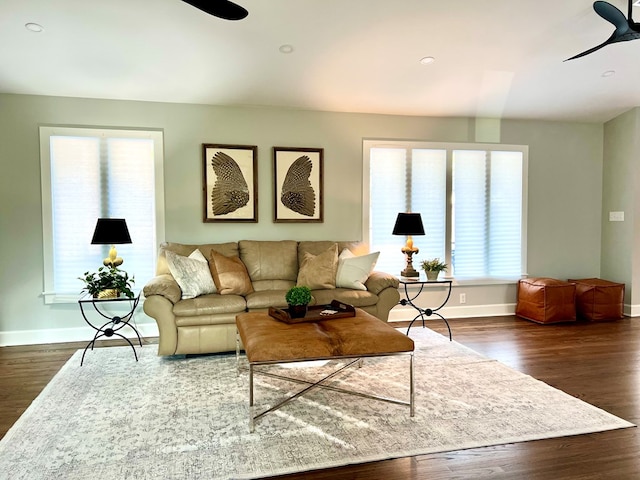 living room with dark wood-type flooring and ceiling fan