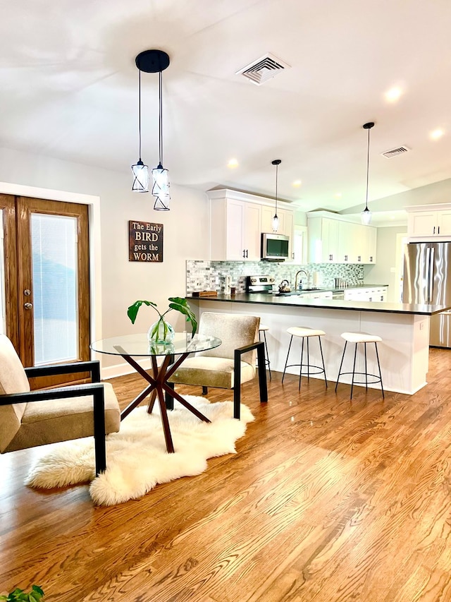 dining room featuring sink and light hardwood / wood-style floors