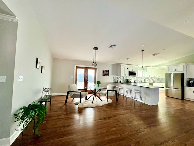 dining room with vaulted ceiling, dark wood-type flooring, and french doors