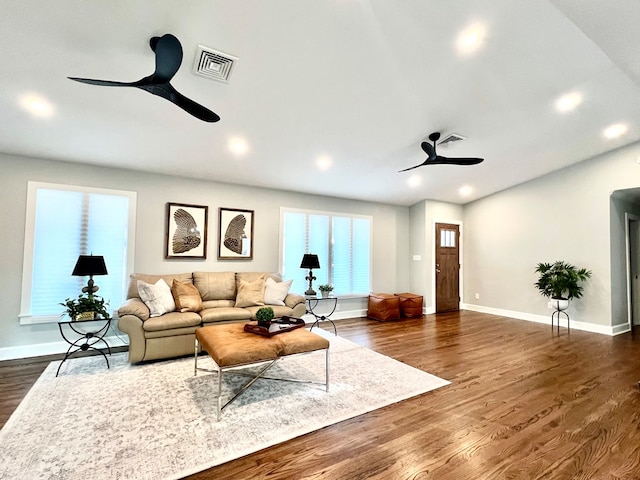 living room featuring ceiling fan and dark hardwood / wood-style floors