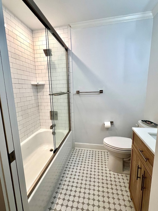 full bathroom featuring crown molding, toilet, vanity, and bath / shower combo with glass door