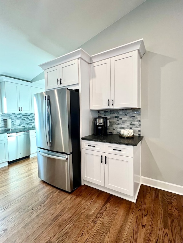 kitchen with stainless steel appliances, hardwood / wood-style floors, and white cabinets