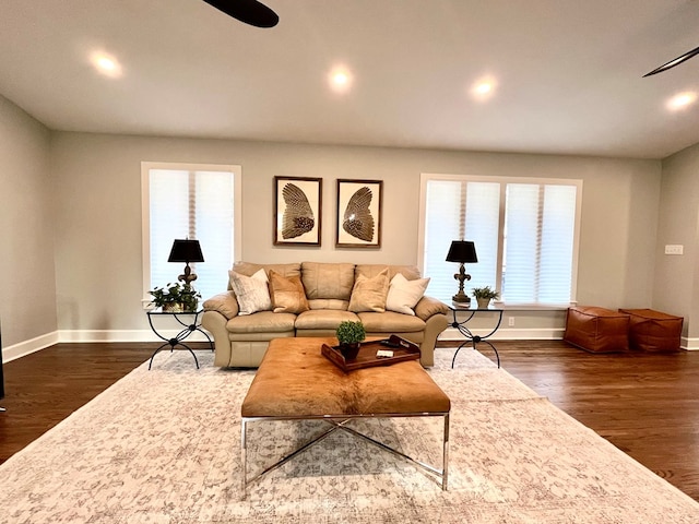 living room with ceiling fan and dark hardwood / wood-style flooring