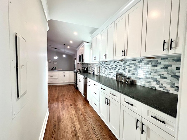 kitchen with decorative backsplash, dishwasher, white cabinets, and decorative light fixtures