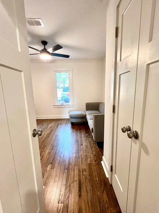 interior space with crown molding, dark hardwood / wood-style floors, and ceiling fan