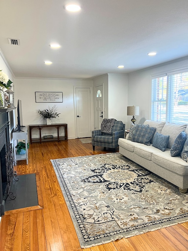 living room with crown molding and wood-type flooring