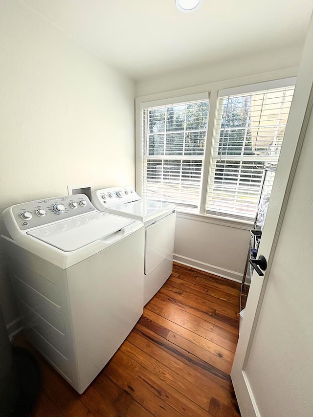 clothes washing area with dark hardwood / wood-style floors and washer and dryer