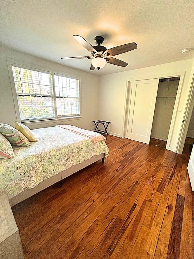 bedroom with dark hardwood / wood-style floors, ceiling fan, and a closet