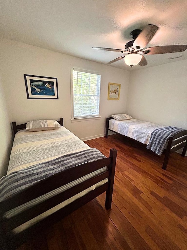 bedroom with ceiling fan and dark hardwood / wood-style floors