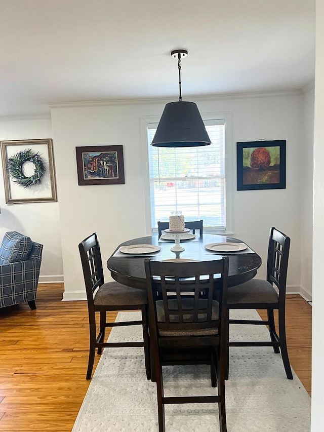 dining space featuring crown molding and hardwood / wood-style floors