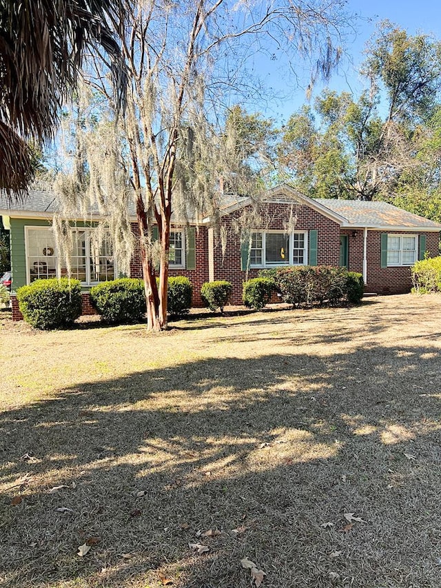 ranch-style home with a garage and a front yard