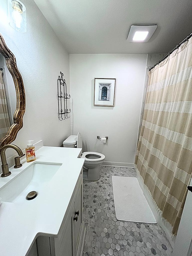 bathroom with vanity, walk in shower, and toilet