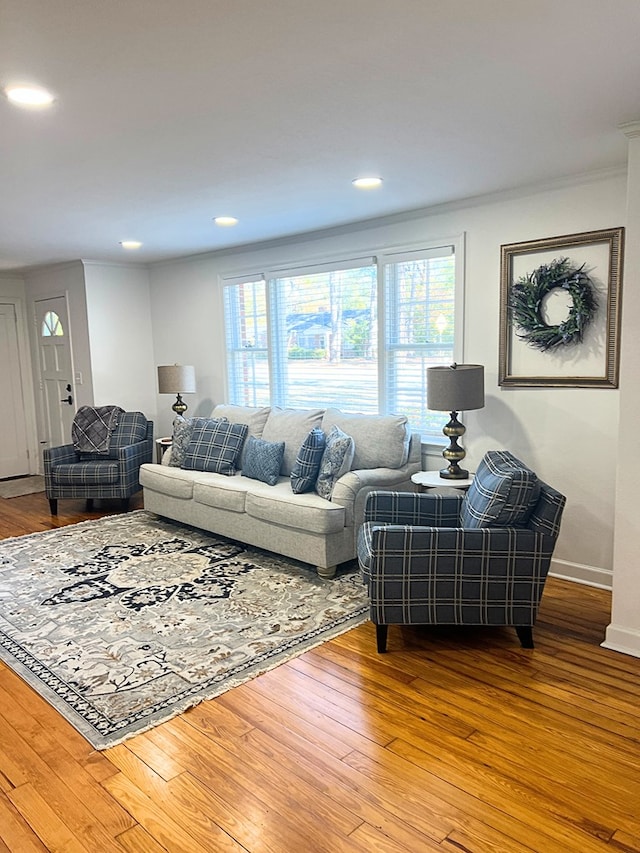 living room featuring hardwood / wood-style flooring, a wealth of natural light, and ornamental molding