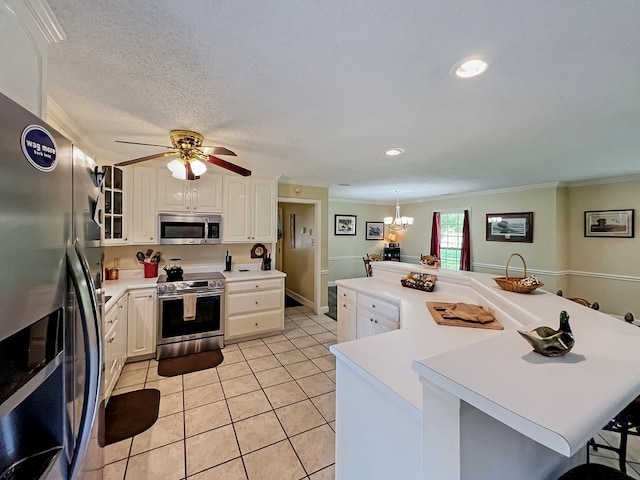 kitchen featuring a kitchen bar, white cabinetry, ornamental molding, and appliances with stainless steel finishes