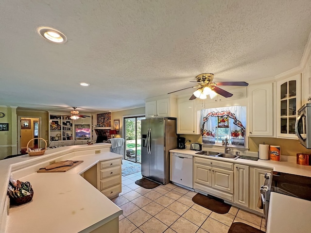 kitchen with appliances with stainless steel finishes, a textured ceiling, ceiling fan, sink, and light tile patterned floors