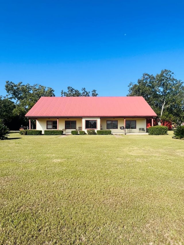 ranch-style house featuring metal roof and a front lawn