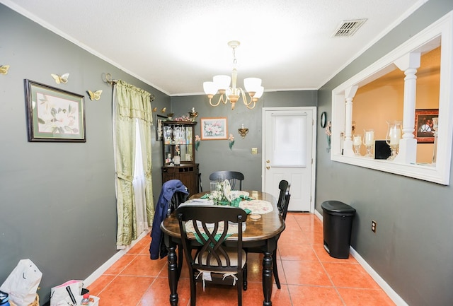 tiled dining area with decorative columns, ornamental molding, and an inviting chandelier