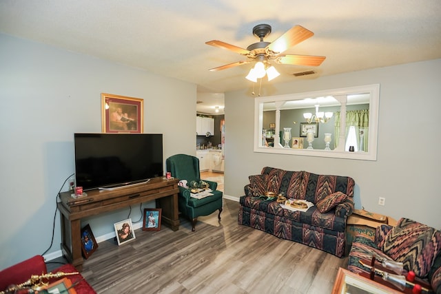 living room featuring a textured ceiling, ceiling fan with notable chandelier, and hardwood / wood-style flooring