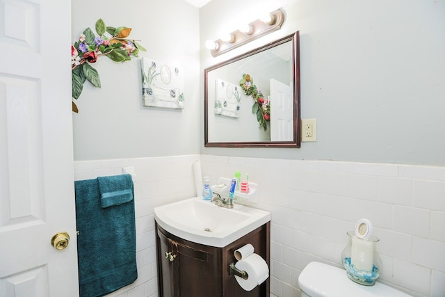 bathroom featuring vanity, tile walls, and toilet
