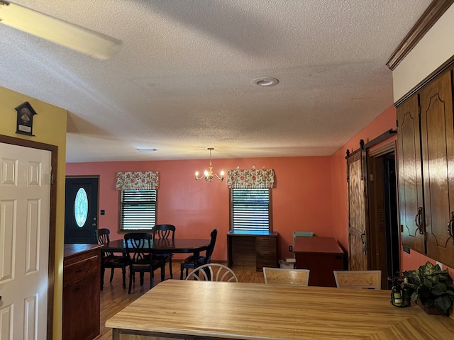 145 Robin Ln, Bainbridge, GA 39819 - dining room featuring a textured ceiling, a chandelier, a barn door, and light wood-type flooring