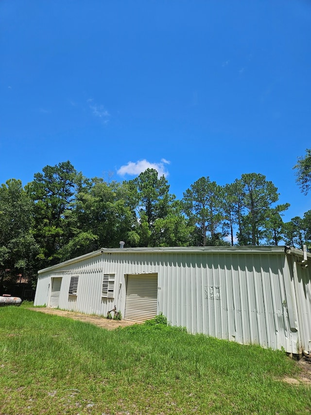 view of side of property with an outbuilding and a lawn