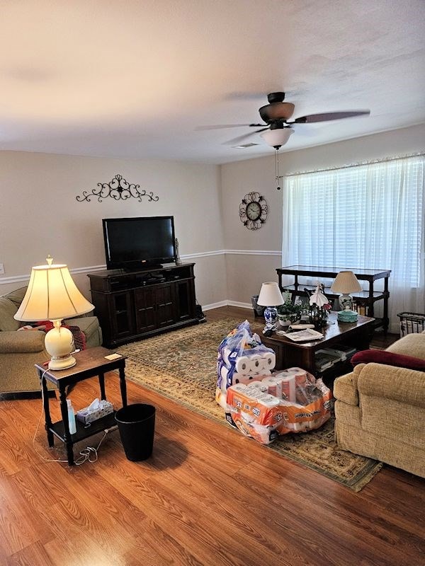 living room featuring wood-type flooring and ceiling fan