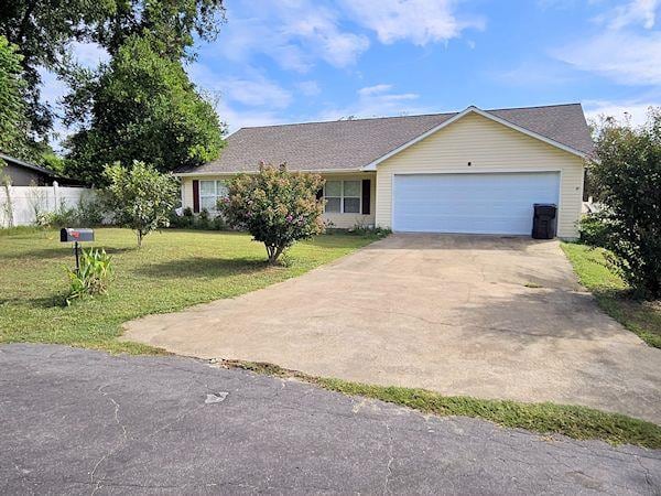 ranch-style home with a garage and a front yard