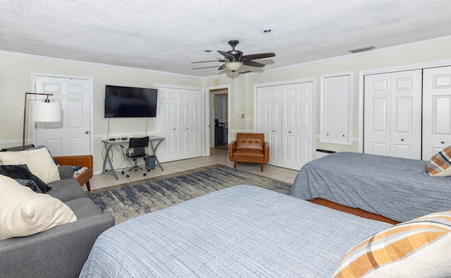 1107 Douglas Dr, Bainbridge, GA 39819 - tiled bedroom with two closets, ornamental molding, a textured ceiling, and ceiling fan