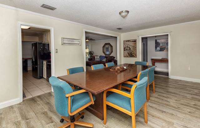 1107 Douglas Dr, Bainbridge, GA 39819 - dining space with a textured ceiling, crown molding, wood finished floors, ceiling fan, and baseboards