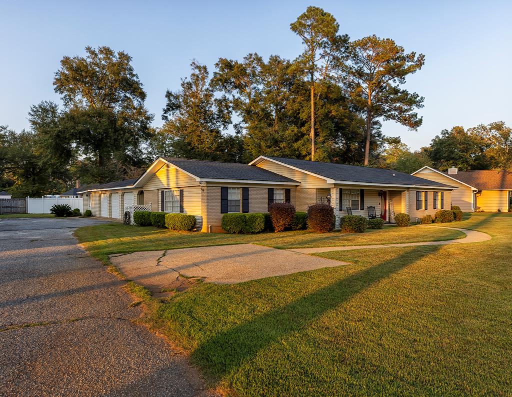 ranch-style house with a porch, a garage, and a front lawn