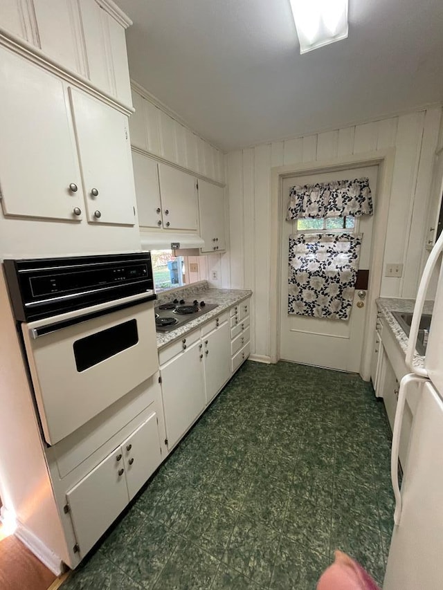 kitchen featuring white oven, stovetop, and white cabinets