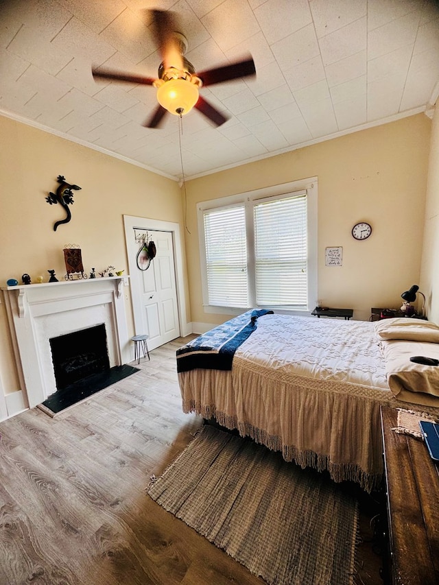 bedroom featuring light hardwood / wood-style flooring, ceiling fan, and crown molding