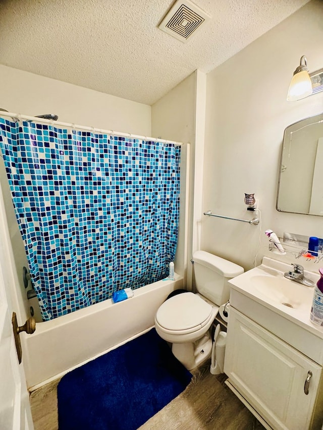 full bathroom featuring hardwood / wood-style floors, vanity, toilet, a textured ceiling, and shower / tub combo