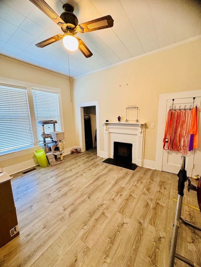 living room with light hardwood / wood-style flooring, ceiling fan, and ornamental molding