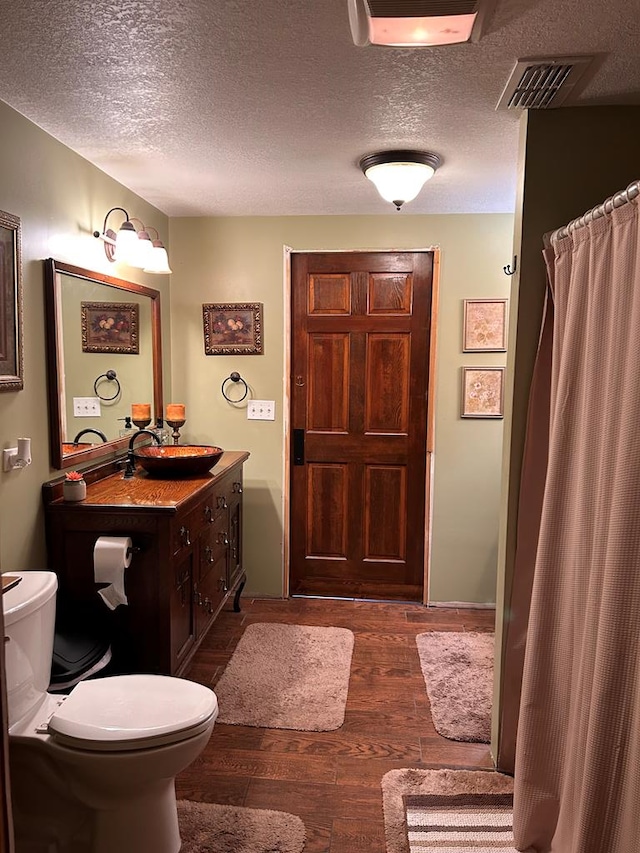 851 Colquitt Hwy, Bainbridge, GA 39817 - full bathroom featuring toilet, wood finished floors, vanity, a textured ceiling, and a shower with curtain