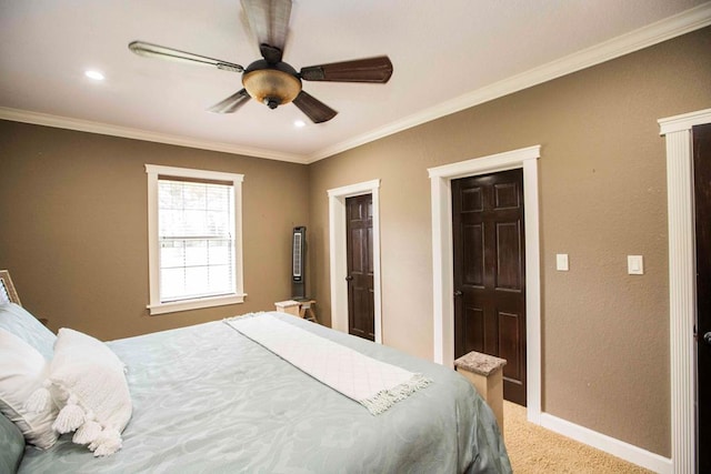 carpeted bedroom with ceiling fan and crown molding