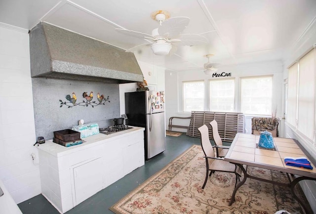 kitchen with ceiling fan, wall chimney exhaust hood, and stainless steel appliances