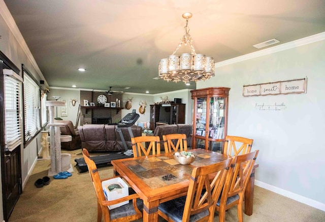 carpeted dining room with a fireplace, ceiling fan with notable chandelier, and ornamental molding