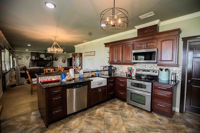 kitchen with decorative light fixtures, kitchen peninsula, sink, and appliances with stainless steel finishes