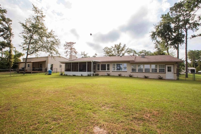 rear view of house with a sunroom and a yard