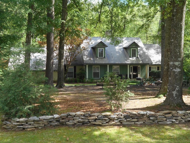 1490 Magnolia Dr, Cairo, GA 39828 - new england style home with covered porch, a chimney, and metal roof