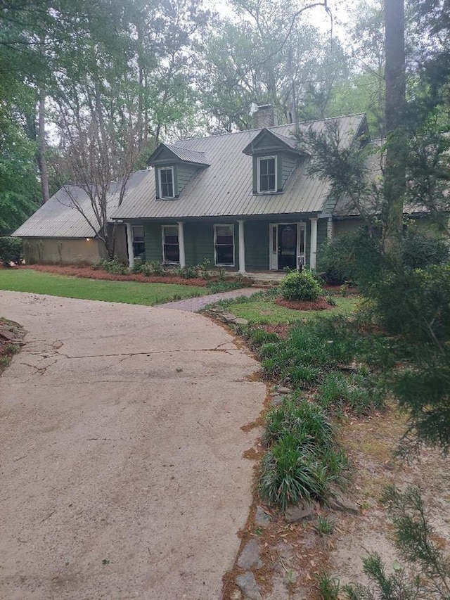 1490 Magnolia Dr, Cairo, GA 39828 - cape cod-style house with a chimney, a porch, and metal roof