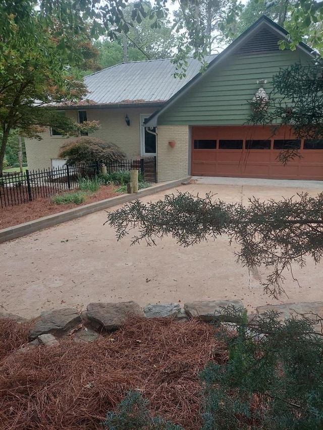 1490 Magnolia Dr, Cairo, GA 39828 - view of front of house featuring brick siding, metal roof, fence private yard, and a garage