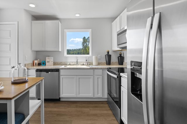 kitchen with dark wood-style flooring, recessed lighting, light countertops, appliances with stainless steel finishes, and a sink