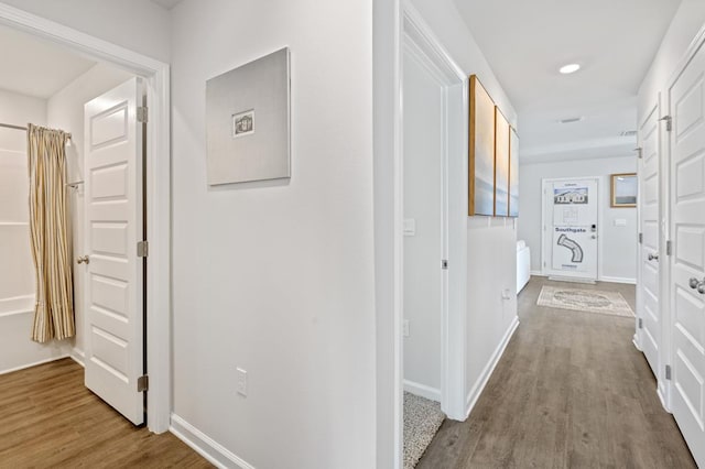 corridor with recessed lighting, baseboards, and wood finished floors