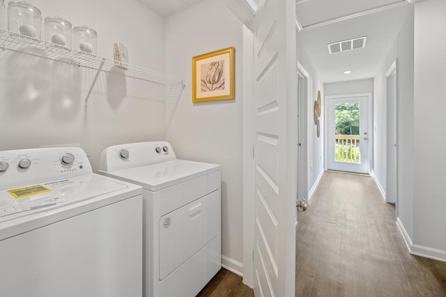 laundry room featuring dark wood-style flooring, visible vents, washer and dryer, laundry area, and baseboards