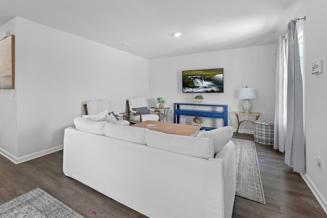 living area featuring baseboards, wood finished floors, and recessed lighting