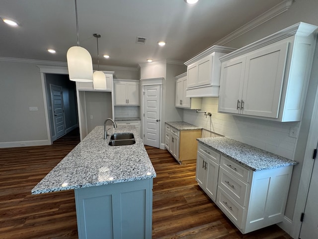 kitchen featuring visible vents, dark wood-type flooring, ornamental molding, white cabinets, and a sink