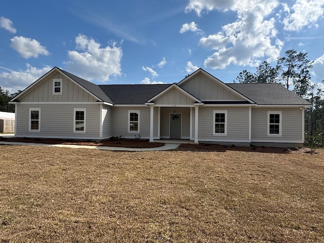 view of front of property featuring a front lawn, board and batten siding, and roof with shingles